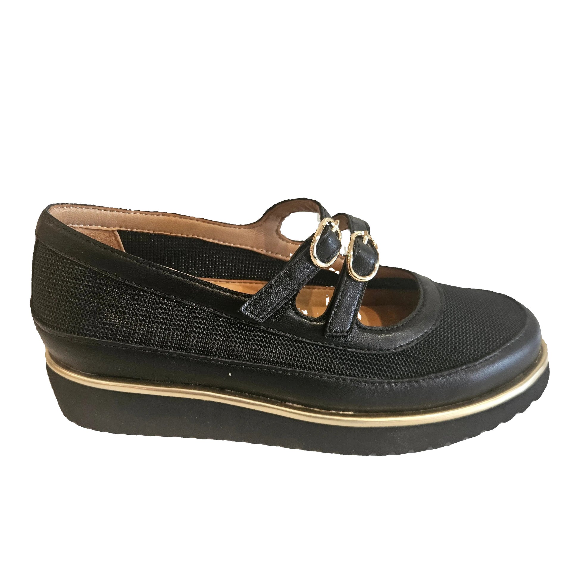 Black shoe with gold accents on a beige surface