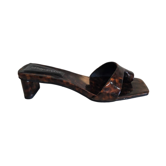 Tortoiseshell sandal with Jeffrey Campbell label on a white surface